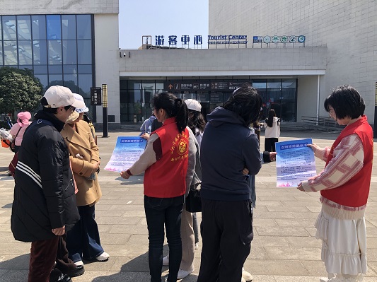 志愿者向游客发放文明旅游倡议书